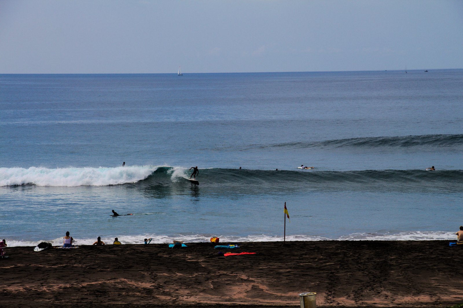Intermediate surfer riding a shoulder-high wave in a crowded lineup