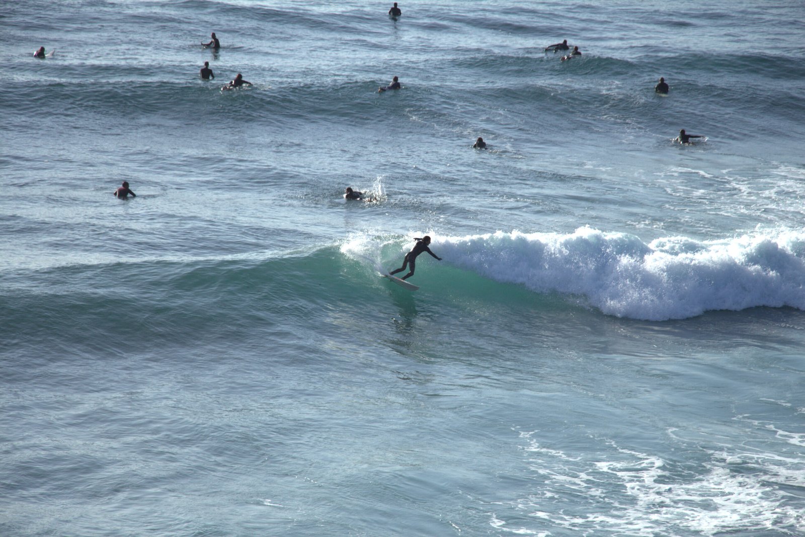Surfer performing a turn while navigating a crowded lineup