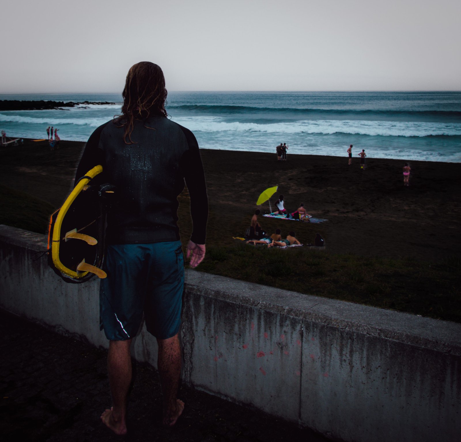 Local surfer holding his board while watching clean waves after a session